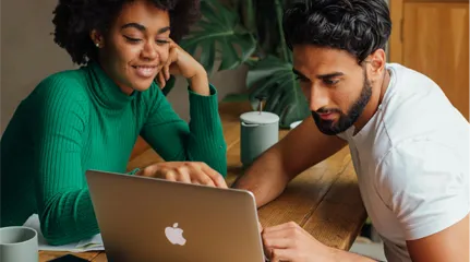 Two people looking at laptop discussing business